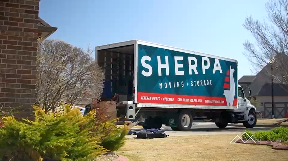 wide shot of moving company truck in neighborhood